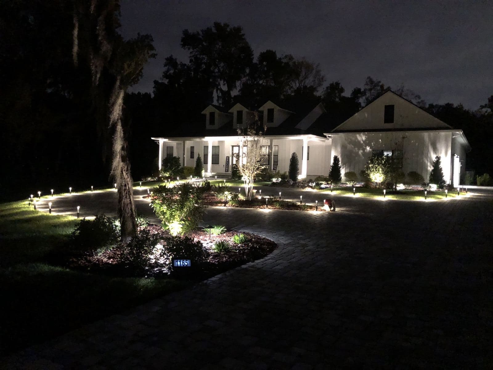 Estate home at night lit with Mastermind Electrical landscape and accent lighting